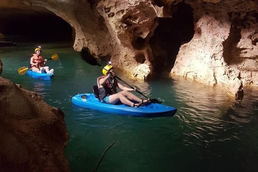 Personas haciendo kayak en una cueva con paredes rocosas. 1