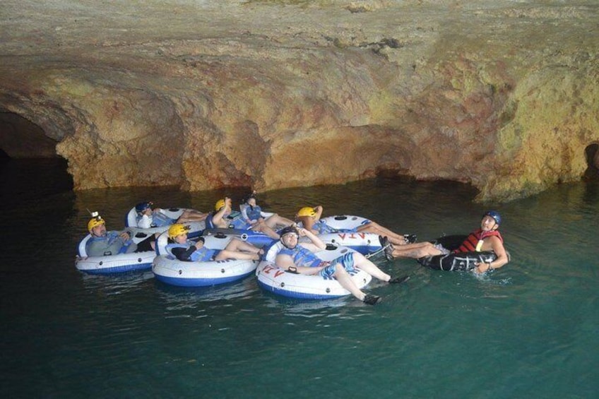 People floating in inflatable rafts in a cave. 1
