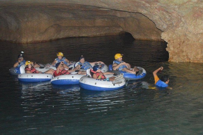 People in inflatable rafts in a cave. 1