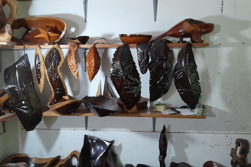 Una serie di sculture e intagli in legno esposti su mensole. 5