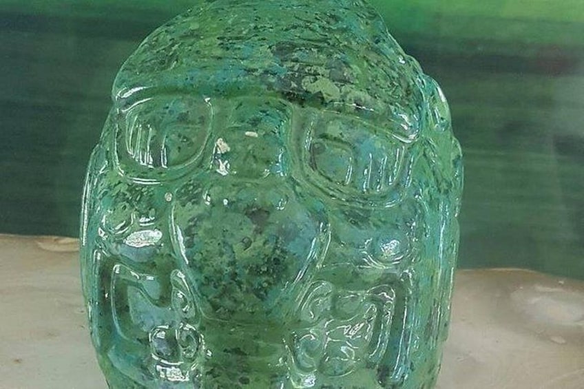 Un objeto de vidrio verde con diseños en relieve. 3