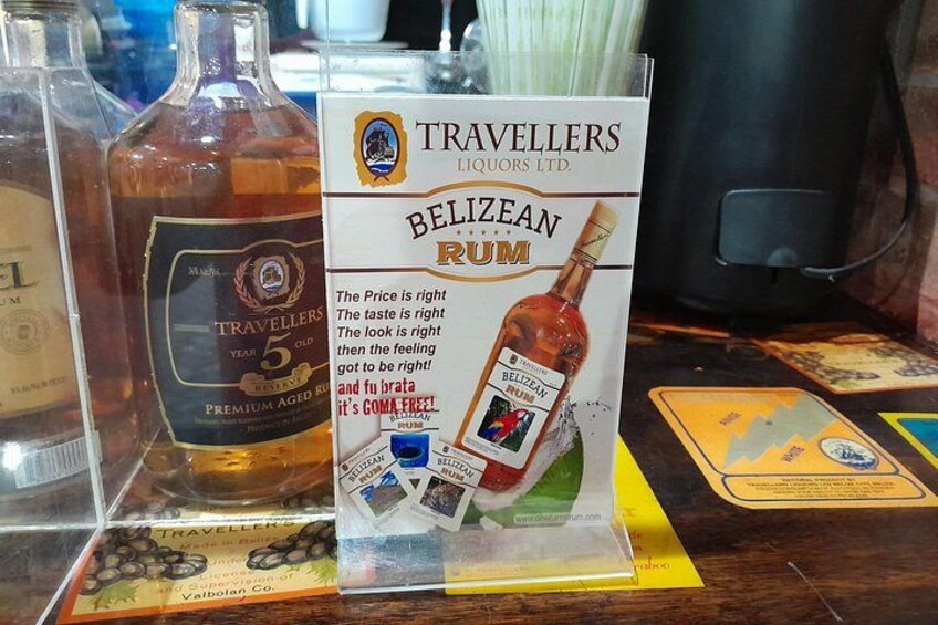 A display of rum bottles and a promotional sign for Belizean Rum. 4