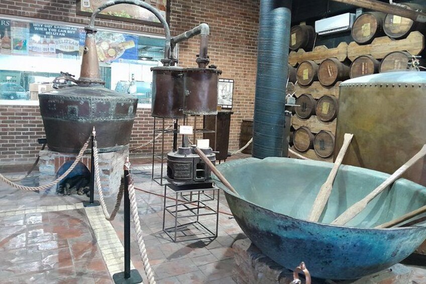 Antique brewing equipment, including large kettles and a barrel. 5