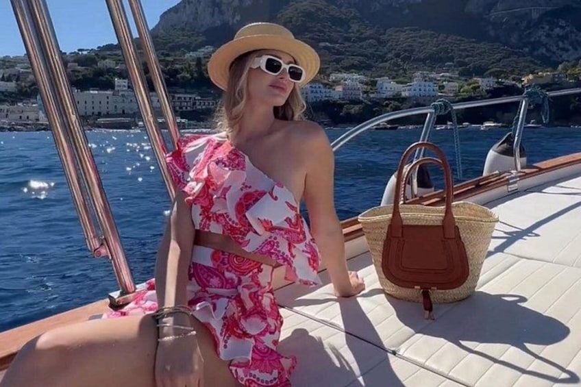 Una persona en un barco con una costa montañosa al fondo. 1