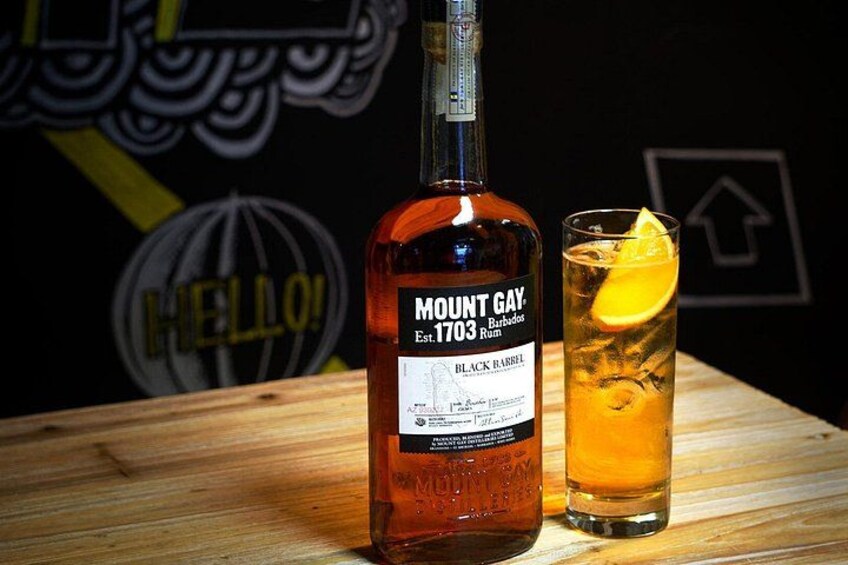 Een fles Mount Gay rum en een glas met een plakje citroen. 1