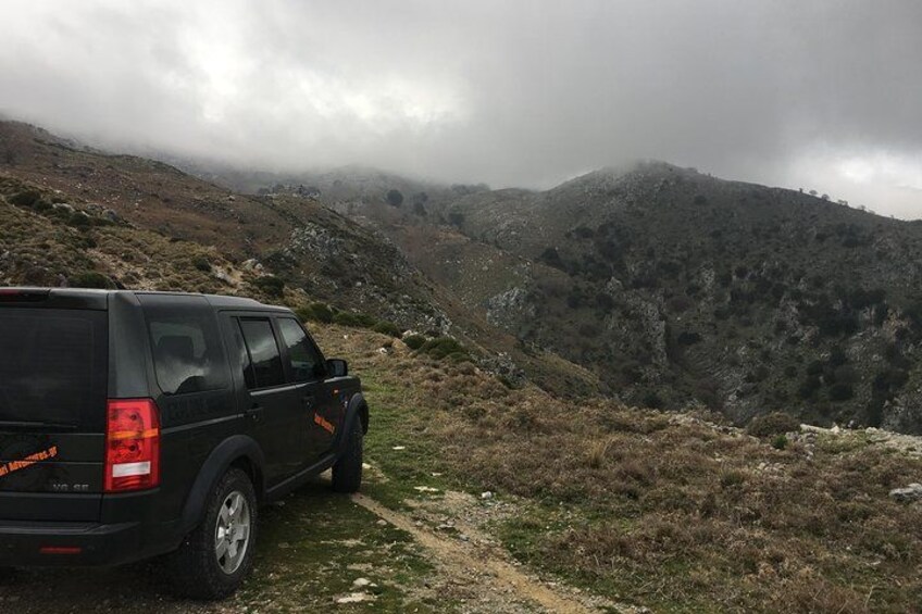 Un VUS noir était garé sur un chemin de terre dans une région montagneuse, caractérisée par un terrain rocheux et une végétation clairsemée. 2