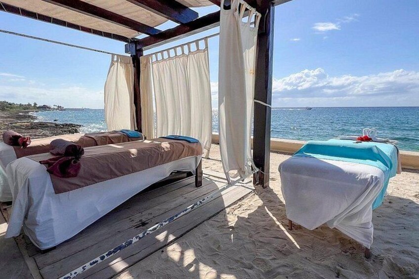 Un letto fronte spiaggia con vista sul mare, un pontile in legno e una zona coperta con tende. 5