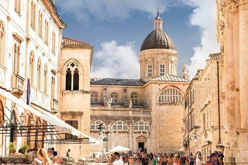 A historic building with a dome and arches, surrounded by a crowd. 4