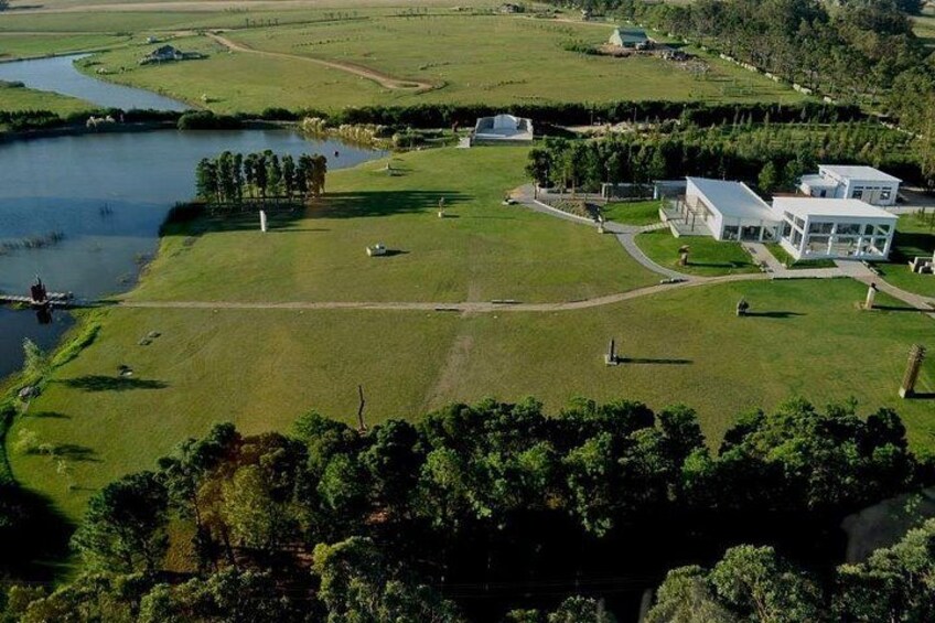 A river, grassy fields, and modern buildings. 1