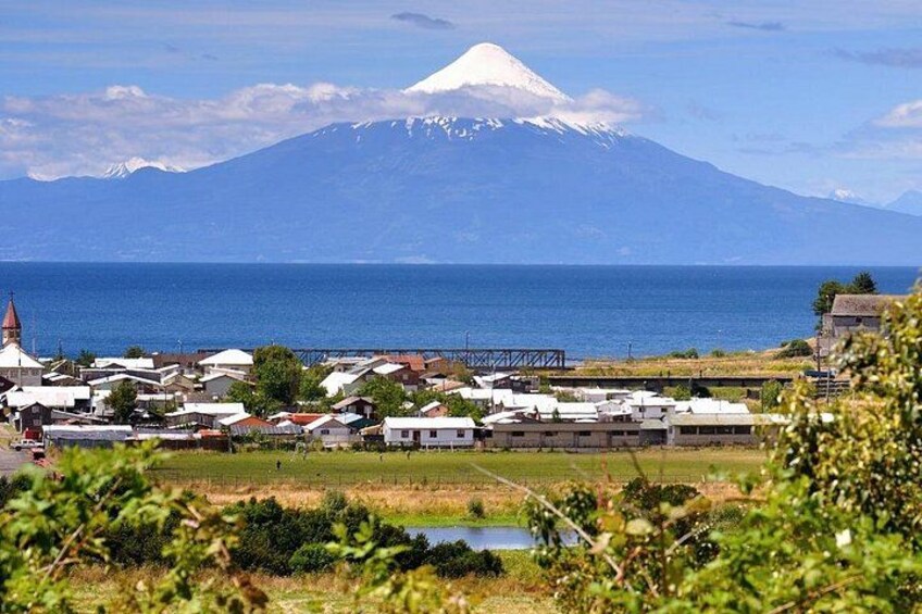 Un pueblo costero con una montaña imponente al fondo. 3