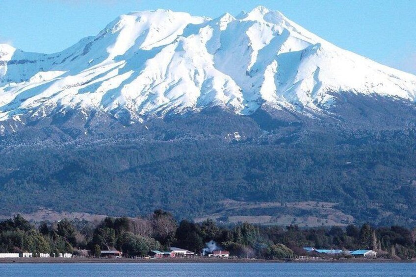 Un monte nevado, un lago y un pequeño asentamiento con edificios. 2