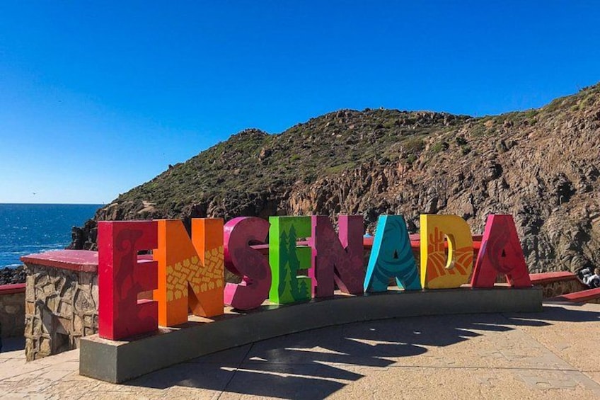 Colorful letters spelling 'ENENADA' with a coastal background. 4