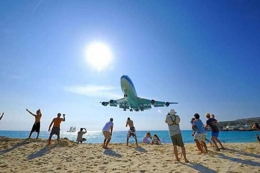 En strand med mennesker og et stort fly i luften. 5