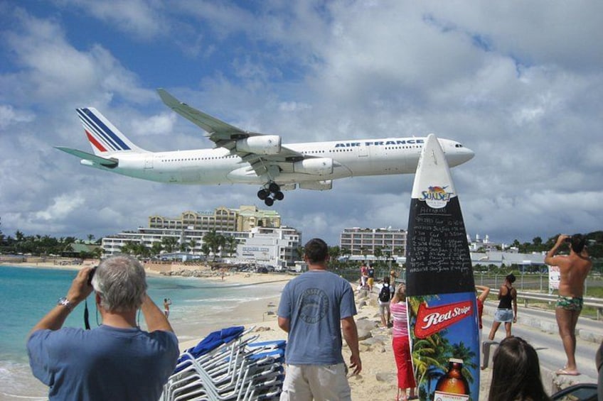 An Air France airplane landing on a beach with people watching. 1