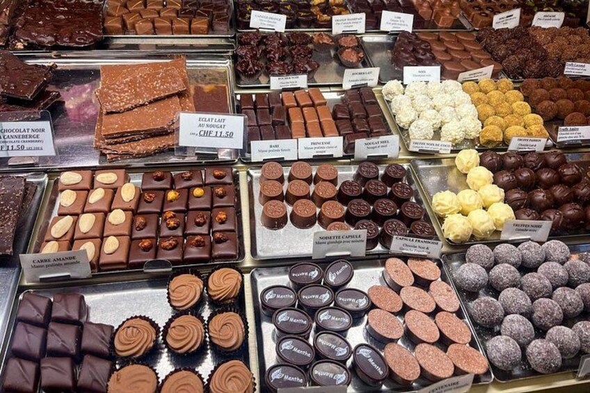 Geneva chocolate tour highlight: curated truffle and praline selection with labeled artisan varieties in boutique display 3