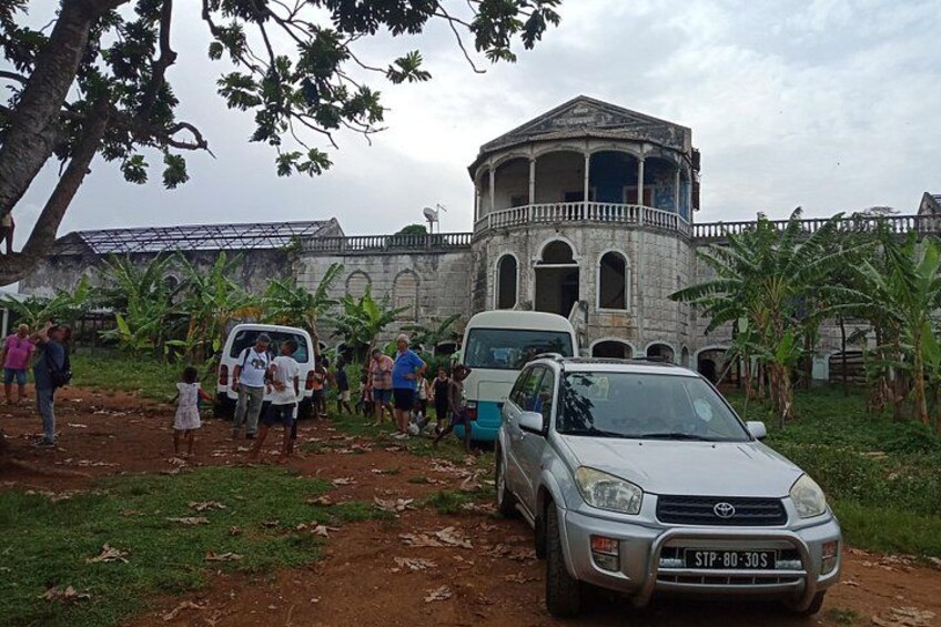 A group of people gathered around a building with a dome and a car parked in front. 4