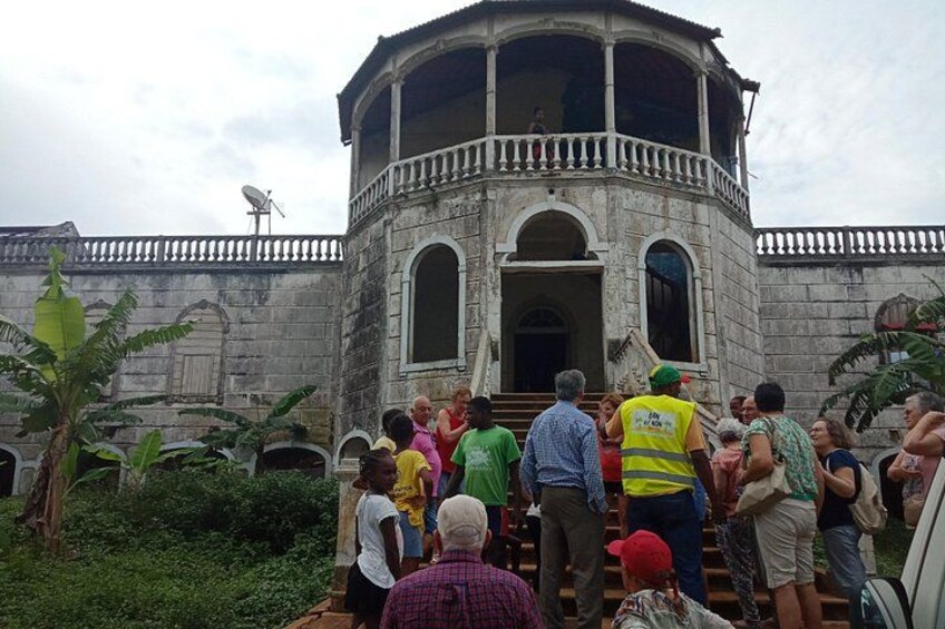 A group of people gathered around a historic building with a dome and arched windows. 5