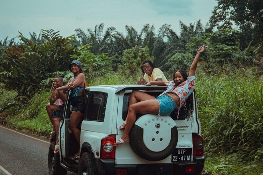A white vehicle with four people on the back, surrounded by greenery. 3