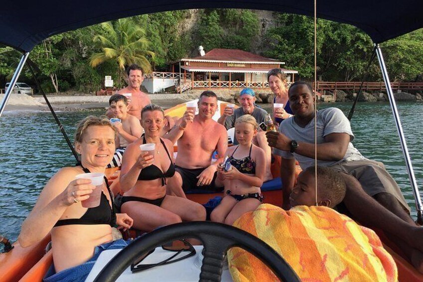 A group of people on a boat with a tropical backdrop, including palm trees and a beach. 5