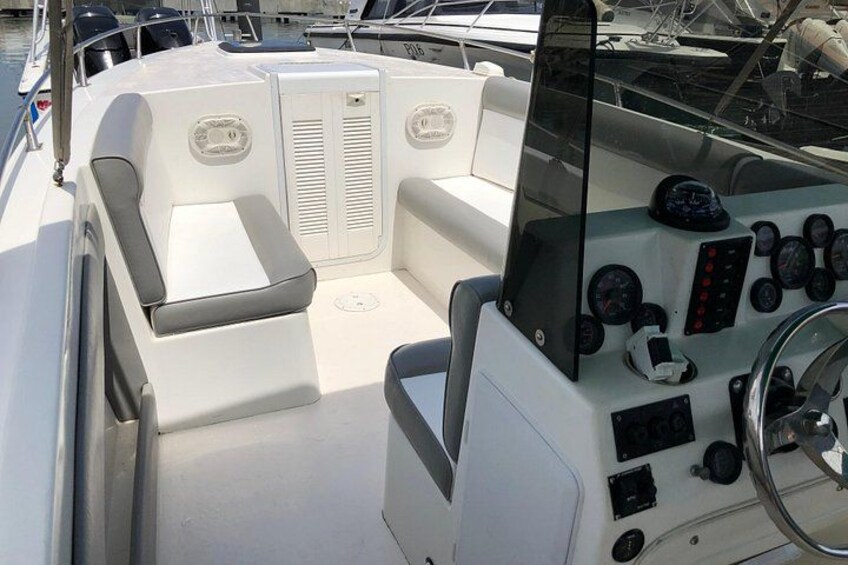Interior de un barco con asientos, paneles de control y timón. 3