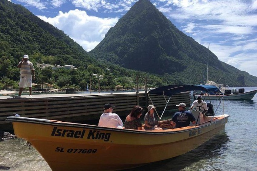 Un bote llamado 'Israel King' atracado en un muelle, con gente a bordo, rodeado por un paisaje montañoso. 5