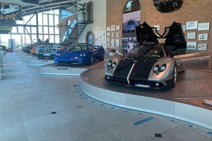 A car showroom with multiple sports cars on display. 4