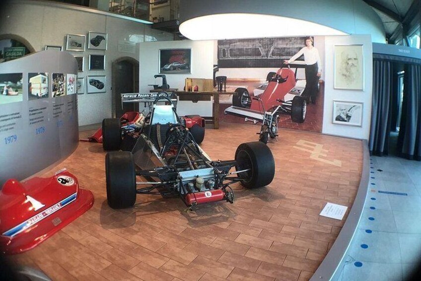 A museum with vintage racing cars on display. 2