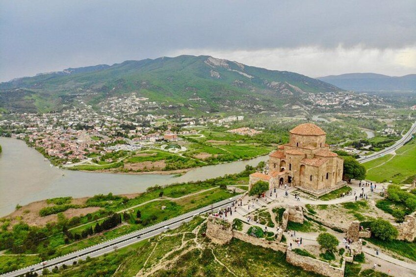 A historic church with a dome, surrounded by a green landscape and a river. 3