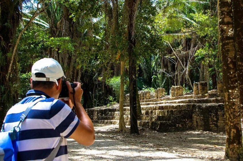 Una persona fotografiando ruinas antiguas rodeadas de árboles. 5