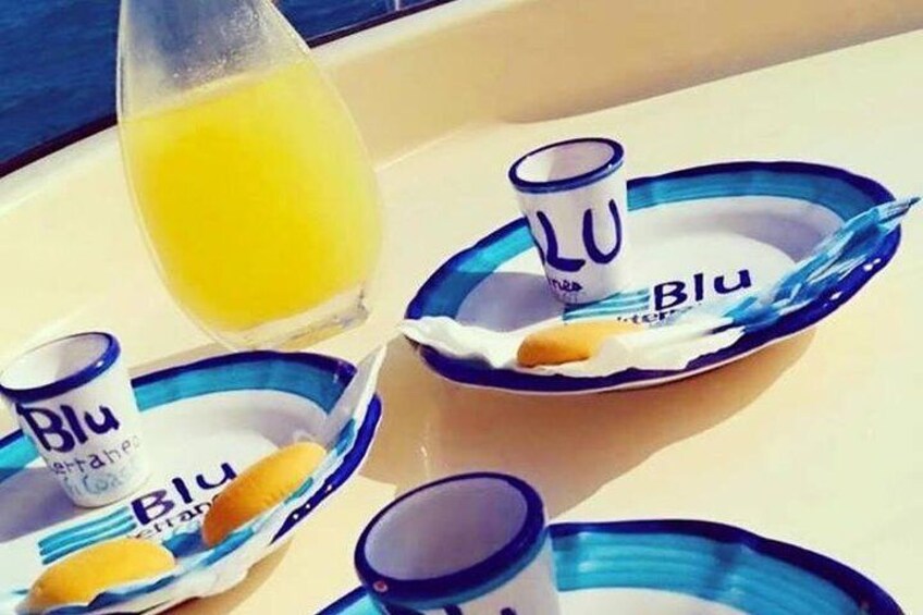 Ett bricka med tre små koppar märkta med ”Blu” och ett glas apelsinjuice. 5