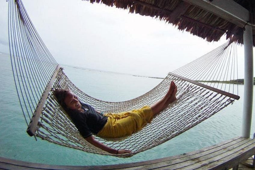 A person lying in a hammock over a body of water. 2