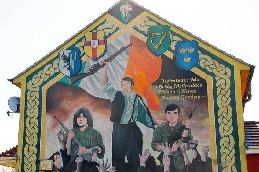 A mural with shields, a person holding a rifle, and text dedicated to individuals. 2