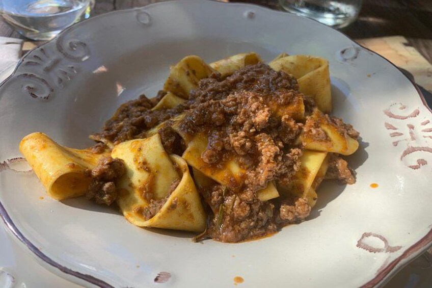 A plate of ravioli with a meat sauce. 4