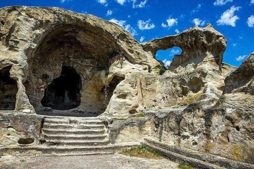Une formation rocheuse dotée d’une entrée de grotte et d’un escalier menant à celle-ci. 2