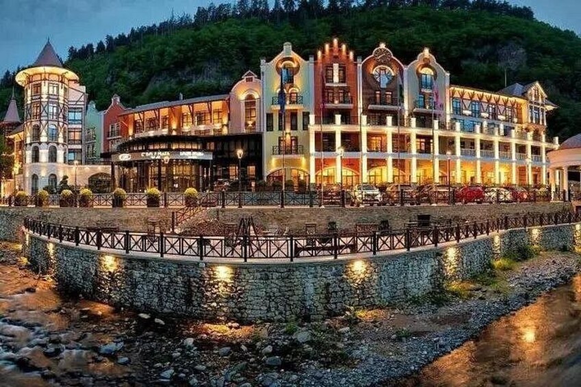Un grand immeuble à étages, avec vue sur le front de mer, et un pont de pierre en premier plan. 3