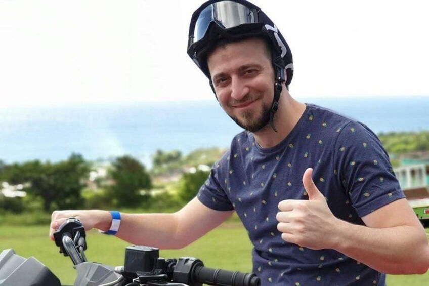 A person riding a motorcycle with a scenic ocean view in the background. 4