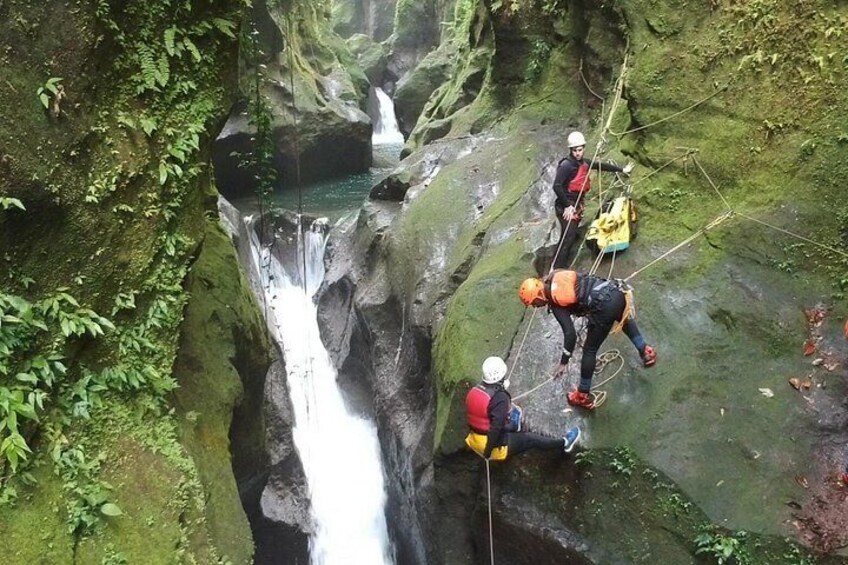 Une cascade où des personnes pratiquent la descente en rappel le long d’une falaise rocheuse. 1