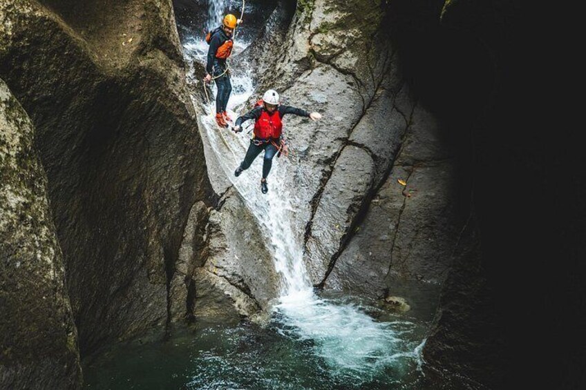 Deux personnes descendent en rappel le long d’une falaise rocheuse pour atterrir dans une étendue d’eau. 3