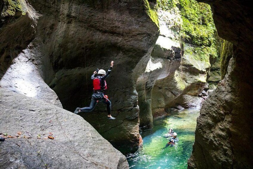 Une personne qui descend en rappel une falaise rocheuse pour atteindre une rivière. 4