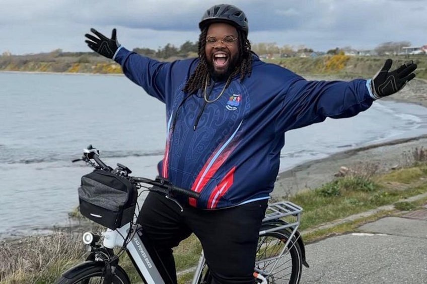 Une personne se tient à côté d’un vélo sur un chemin pavé, près d’une étendue d’eau. 2