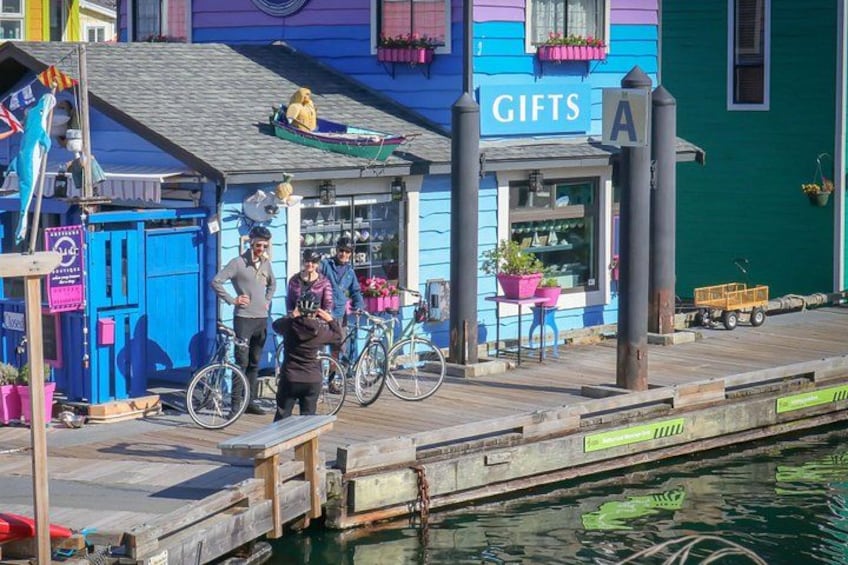 Une promenade en bord de mer avec un bâtiment aux couleurs vives portant l’inscription « CADEAUX », un quai et une rangée de vélos. 5
