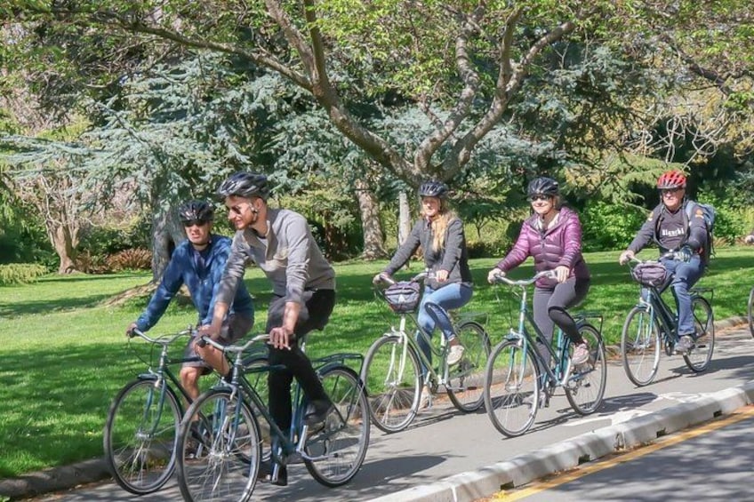 Un groupe de cyclistes sur une piste asphaltée, dans un parc avec des arbres et de l’herbe. 3