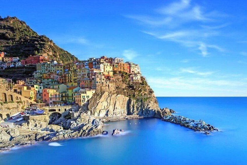 Un borgo costiero con edifici colorati arroccati su una scogliera affacciata sul mare. 1