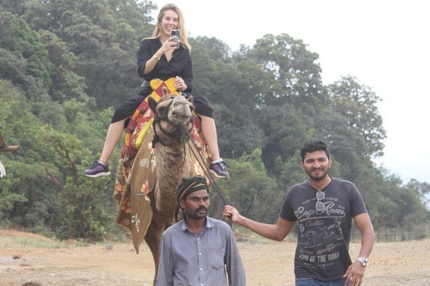 A person riding a camel, another person walking beside it, and a third person holding the camel's reins. 4