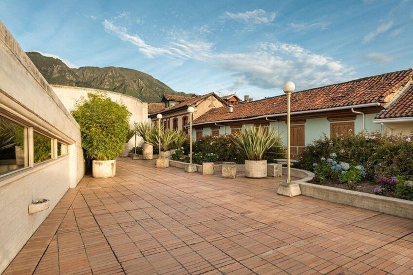 A courtyard with tiled flooring, potted plants, and buildings with tiled roofs. 4