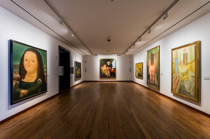 An art gallery with wooden floors and paintings on the walls. 3