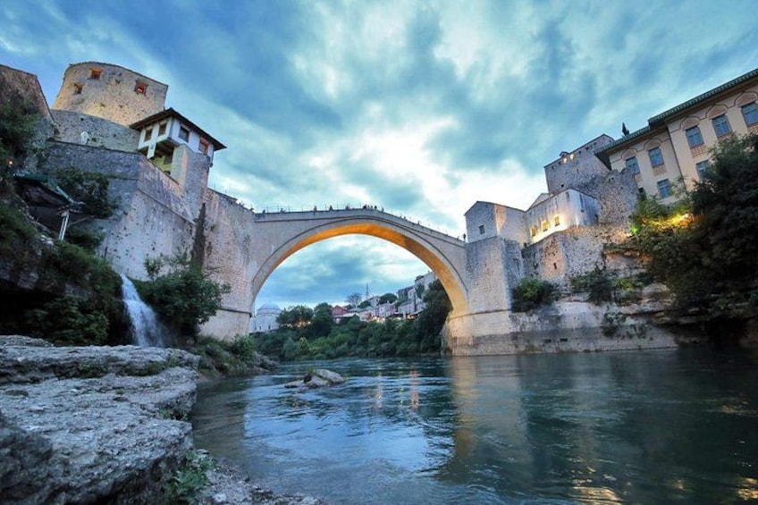 Un puente de piedra sobre un río, rodeado de edificios históricos y un castillo. 1