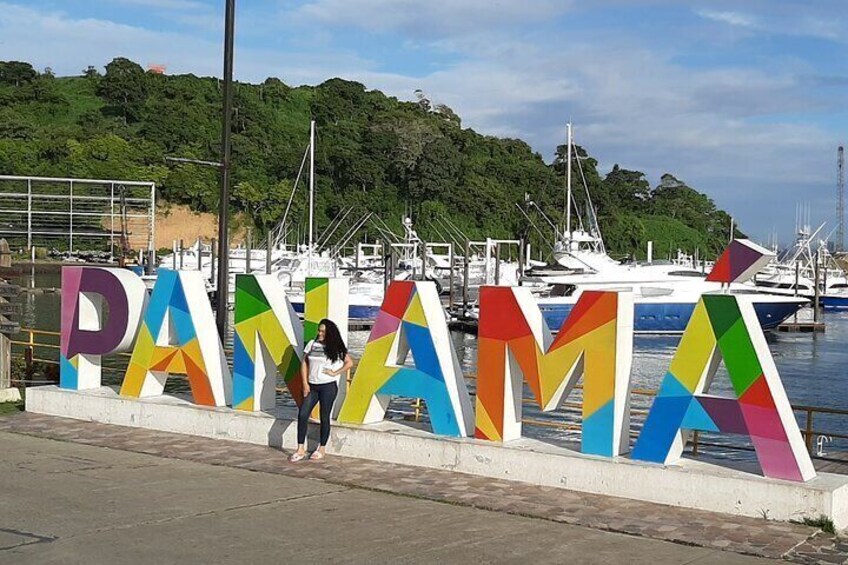 Une enseigne colorée sur laquelle on peut lire le mot « PANAMA », avec une personne qui marche devant. 1