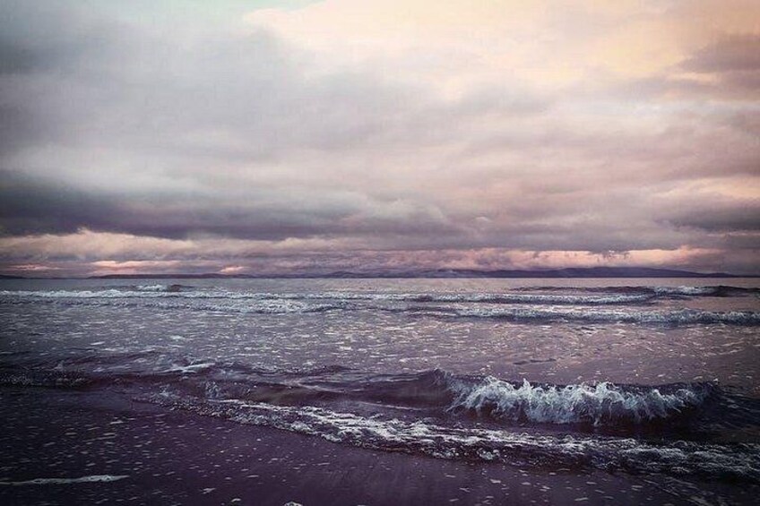 Een strand met golven en een bewolkte lucht. 2