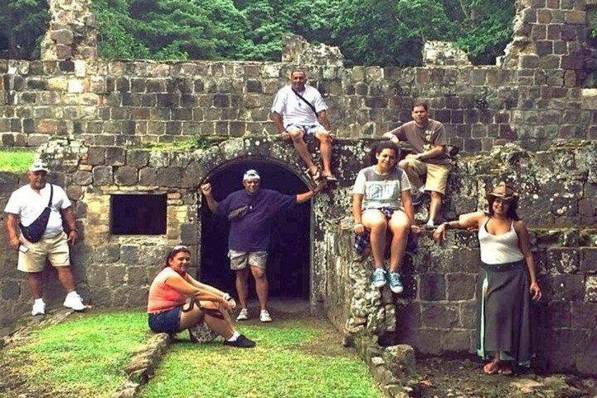 A group of people at an ancient stone structure with a tunnel entrance. 4